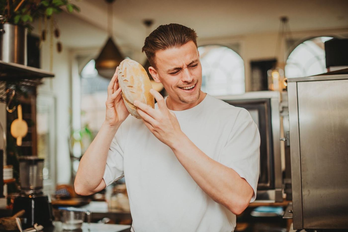 Daan met een vers zuurdesembrood in zijn keuken